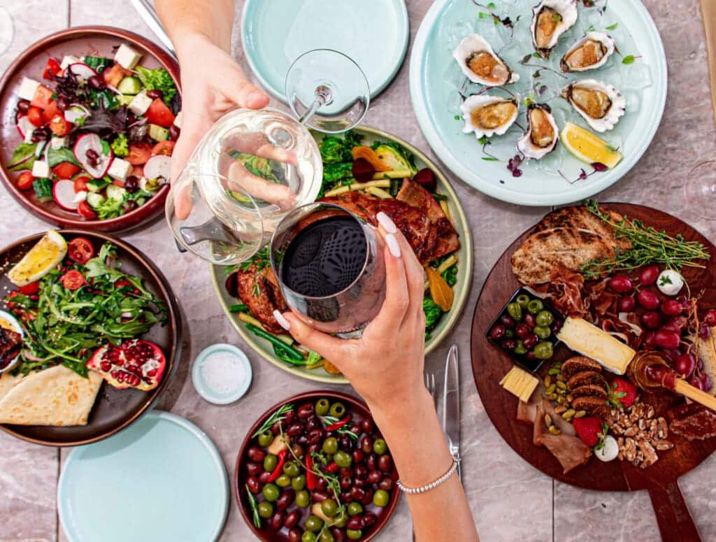Table spread with salads, oysters and sharing plates for a group dinner