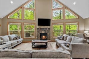 Living room at the Epic Lake Harmony Group Getaway with a stone fireplace and A-frame windows