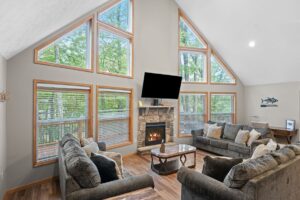 Living room at The Mountain Getaway with a stone fireplace and tall A-frame windows